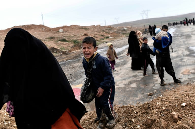 Iraqi civilians walk down a road as they flee the fighting in west Mosul, northern Iraq on March 3, 2017