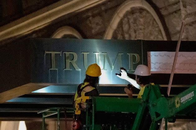 Workers remove the signage for the Trump International Hotel on May 11, 2022, in Washington. The lease to the Washington, D.C., hotel run by Donald Trump&#39;s family company while he was president, has been sold by his family company to a Miami-based investor fund.&#xa0; (Photo: AP Photo/Gemunu Amarasinghe)