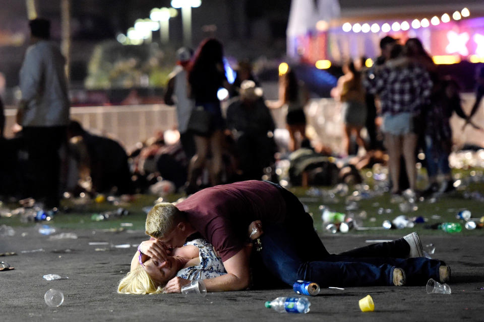 A man lies on top of a woman as others flee the Route 91 Harvest festival grounds after a gunman fired on the event in Las Vegas last October. (Photo: David Becker/Getty Images)