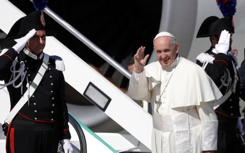 Pope Francis waves as he boards the plane for his five-day trip to Colombia, at Rome's Leonardo da Vinci international airport  - Credit: Gregorio Borgia/AP