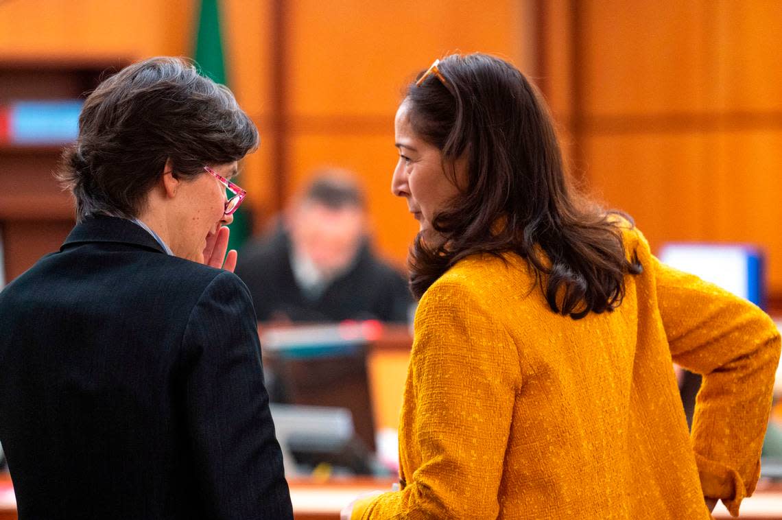 Washington state assistant attorneys general Melanie Tratnik (left) and Barbara Serrano talk before Tacoma Police Officer Zachary Hobbs testifies on Monday, Dec. 5, 2022, in Pierce County District Court in Tacoma.