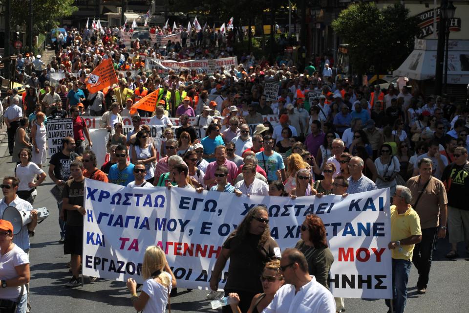 Greek municipal employees protest at planned government funding cuts in Athens, on Wednesday, Aug. 29, 2012. More than 1,000 people took part in the protest. The banner reads: "I owe money, my grandmother owes money, it's too much for my unborn children to also be in debt." The three partners in Greece's coalition government agreed Wednesday on the broad outlines of a new euro11.5-billion austerity package that is demanded for Greece to continue receiving its rescue loans, the country's finance minister said. (AP Photo/Petros Giannakouris)