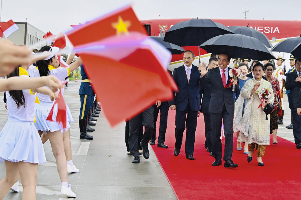 In this photo released by the Press and Media Bureau of the Indonesian Presidential Palace, Indonesian President Joko Widodo, second right, and his wife Iriana, right, wave as they are greeted by dancers upon arrival at Chengdu Tianfu International Airport in Chengdu, China, Thursday, July 27, 2023. Indonesian President Joko Widodo arrived Thursday in China and planned to meet with Chinese leader Xi Jinping, a state news agency reported. (Laily Rachev/Indonesian Presidential Palace via AP)
