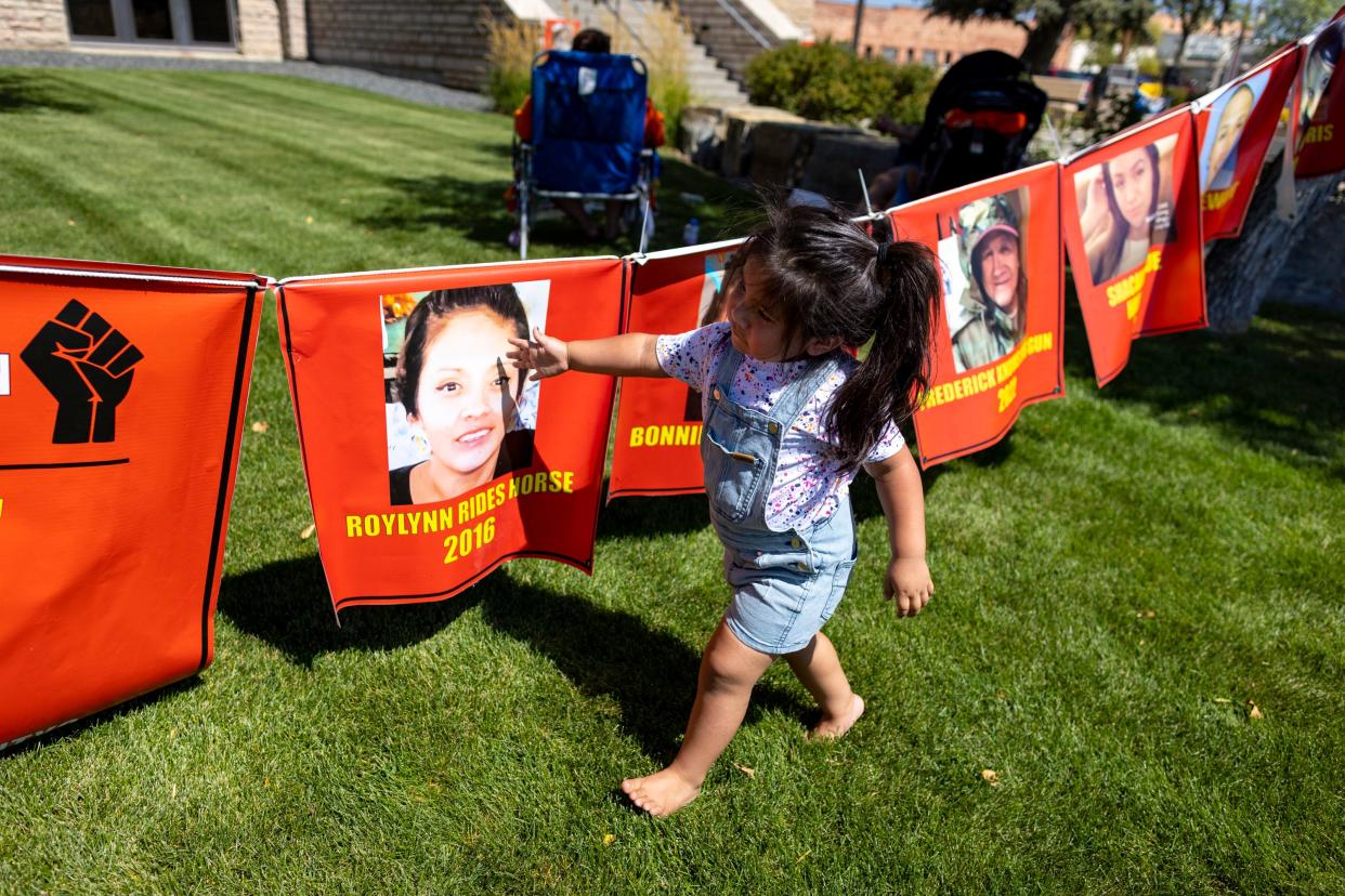 Bernice Old Bull looks at banners hanging during a rally in support of the Missing and Murdered Indigenous People movement at the Big Horn County Building on Tuesday, Aug. 29, 2023, in Hardin, Mont. Old Bull's uncle Braven Glenn was killed while being pursued by a Crow Tribal Police officer. The Crow Tribal Police Department has since been disbanded and Glenn's mother Blossom Old Bull has been critical of the amount of information she has received regarding the circumstances of her son's death. (AP Photo/Mike Clark)