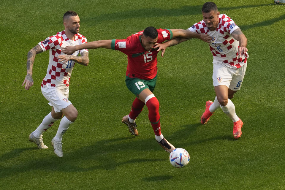 Croatia's Marcelo Brozovic, left, Morocco's Selim Amallah, Croatia's Dejan Lovren, vie for the ball during the World Cup group F soccer match between Morocco and Croatia at the Al Bayt Stadium in Al Khor, Qatar, Wednesday, Nov. 23, 2022. (AP Photo/Darko Vojinovic)