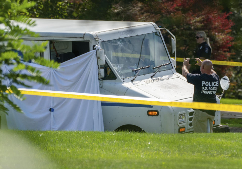 Police investigate the scene of a fatal shooting of a postal worker in front of a house on Suburban Ave. in Collier Township, Pa., outside of Pittsburgh, on Thursday, Oct. 7, 2021. (Andrew Rush/Pittsburgh Post-Gazette via AP)