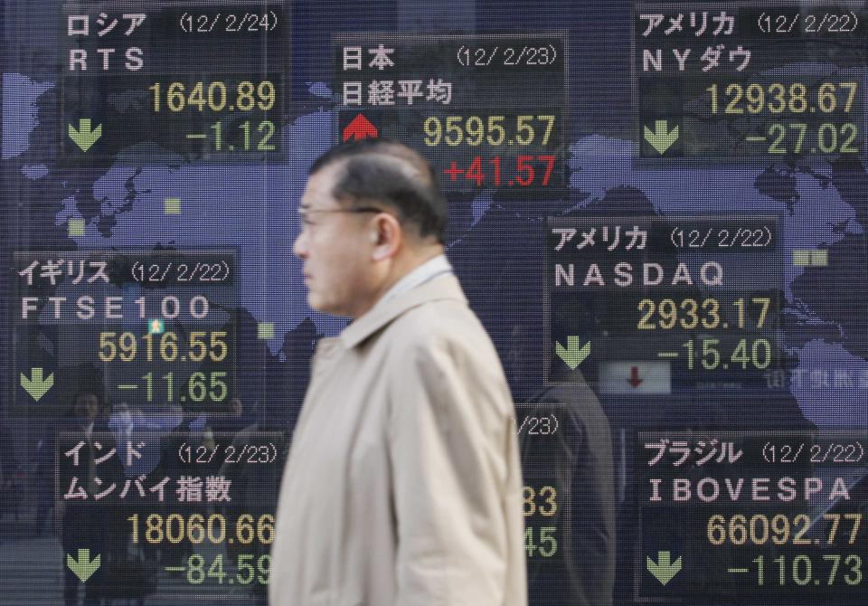 A man walks by an electronic stock board of a securities firm in Tokyo,Thursday, Feb. 23, 2012. Asian stock markets were mostly lower Thursday as investors fretted over the details of a deal to save Greece from financial collapse and preserve its place among nations that use the euro. But Japan's 225 Nikkei added 41.57 points to 9,595.57 as the dollar traded near a seven-month high against the yen. (AP Photo/Koji Sasahara)