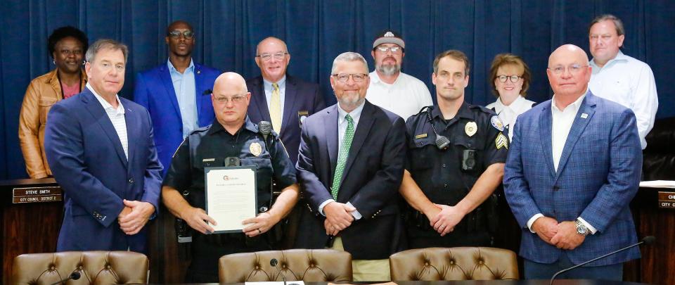 Two law enforcement offficers were honored at the June 27 meeting of the Gadsden City Council for their actions during an incident on June 9, 2022, in which an intruder tried to break into Walnut Park Elementary School with summer campers inside. From left at front are Gadsden Mayor Craig Ford, Gadsden Police officer Tim Humphries, Gadsden Police Chief Lamar Jaggears, Rainbow City Police Sgt. Richard Roberts and Rainbow City Mayor Joe Taylor. From left at rear are council members Tonya Latham, Larry Avery, Kent Back, Jason Wilson, Dixie Minatra and Chris Robinson.