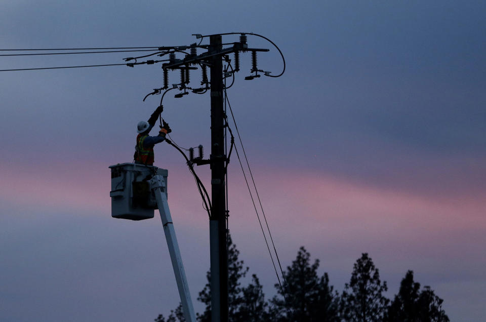 FILE - In this Nov. 26, 2018, file photo, a Pacific Gas & Electric lineman works to repair a power line in fire-ravaged Paradise, Calif. Two years to the day after some of the deadliest wildfires tore through Northern California wine country, two of the state's largest utilities were poised Tuesday, Oct. 8, 2019, to shut off power to more than 700,000 customers in 37 counties, in what would be the largest preventive shut-off to date as utilities try to head off wildfires caused by faulty power lines. (AP Photo/Rich Pedroncelli, File)