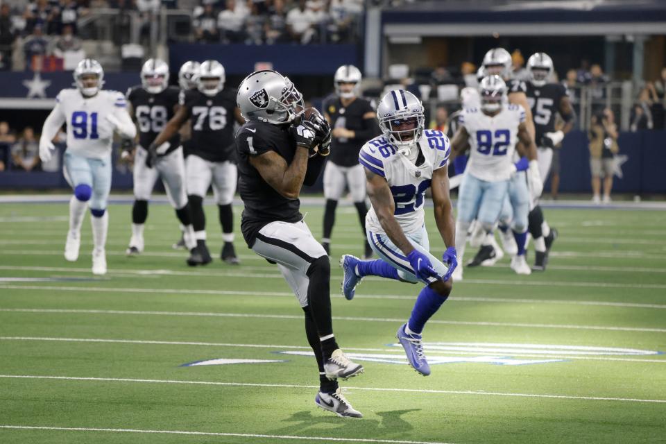 Las Vegas Raiders wide receiver DeSean Jackson (1) catches a pass for a touchdown as Dallas Cowboys cornerback Jourdan Lewis (26) defends in the first half of an NFL football game in Arlington, Texas, Thursday, Nov. 25, 2021. (AP Photo/Michael Ainsworth)