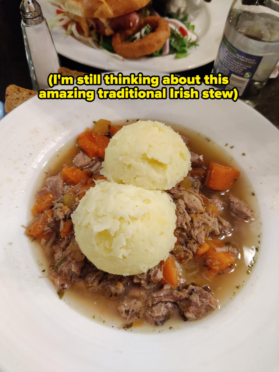 Plate of traditional Irish stew with mashed potatoes served on a table