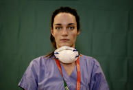 Martina Papponetti, 25, a nurse at the Humanitas Gavazzeni Hospital in Bergamo, Italy poses for a portrait at the end of her shift, March 27, 2020. (AP Photo/Antonio Calanni)