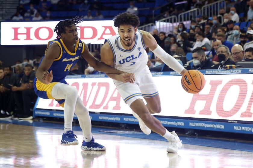 UCLA guard Johnny Juzang, right, drives past Cal State Bakersfield guard Kaleb Higgins during the second half of an NCAA college basketball game Tuesday, Nov. 9, 2021, in Los Angeles. UCLA won 95-58. (AP Photo/Ringo H.W. Chiu)