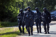 Members of the Lithuanian Police Anti-terrorist Operations Unit ARAS arrive at the refugee camp in the village of Vydeniai, Lithuania, Saturday, July 10, 2021. European Union member Lithuania has declared a state of emergency due to an influx of migrants from neighboring Belarus in the last few days. Lithuania's interior minister said late Friday that the decision, proposed by the State Border Guard Service, was necessary not because of increased threats to the country of 2.8 million but to put a more robust system in place to handle migrants. (AP Photo/Mindaugas Kulbis)