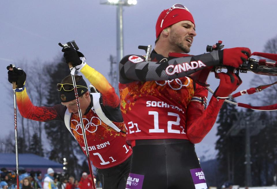 Germany's Erik Lesser (L) leaves the shooting range next to Canada's Jean-Philippe Le Guellec during the men's biathlon 4 x 7.5 km relay at the Sochi 2014 Winter Olympic Games in Rosa Khutor February 22, 2014. REUTERS/Sergei Karpukhin (RUSSIA - Tags: SPORT BIATHLON OLYMPICS)