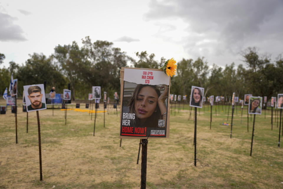 The photos of people taken captive and killed by Hamas militants during their violent rampage through the Nova music festival in southern Israel are displayed at the site of the event, as Israeli DJs spun music, to commemorate the October 7, massacre, near kibbutz Re'im, Tuesday, Nov. 28, 2023. (AP Photo/Ohad Zwigenberg)