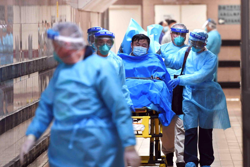 Medical staff transfer a patient of a highly suspected case of a new coronavirus at the Queen Elizabeth Hospital in Hong Kong, China January 22, 2020. [Photo: Reuters]