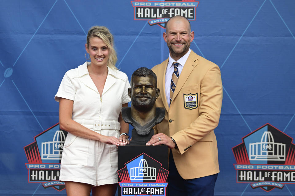 Former NFL player Joe Thomas, right, and his wife Annie pose with his bust during his induction into the Pro Football Hall of Fame in Canton, Ohio, Saturday, Aug. 5, 2023. (AP Photo/David Dermer)