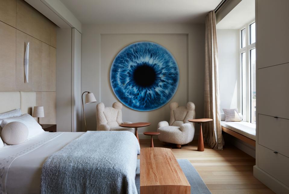 Pierre Jovanovitch’s “Papa Bear” armchairs, seen here in Anna Zaoui’s bedroom, had been unavailable for purchase until The Invisible Collection began selling them. The three mushroom-shaped occasional tables were also designed by Yovanovitch. A very special custom work by British artist Marc Quinn, depicting Zaoui’s own iris, hangs on the wall.