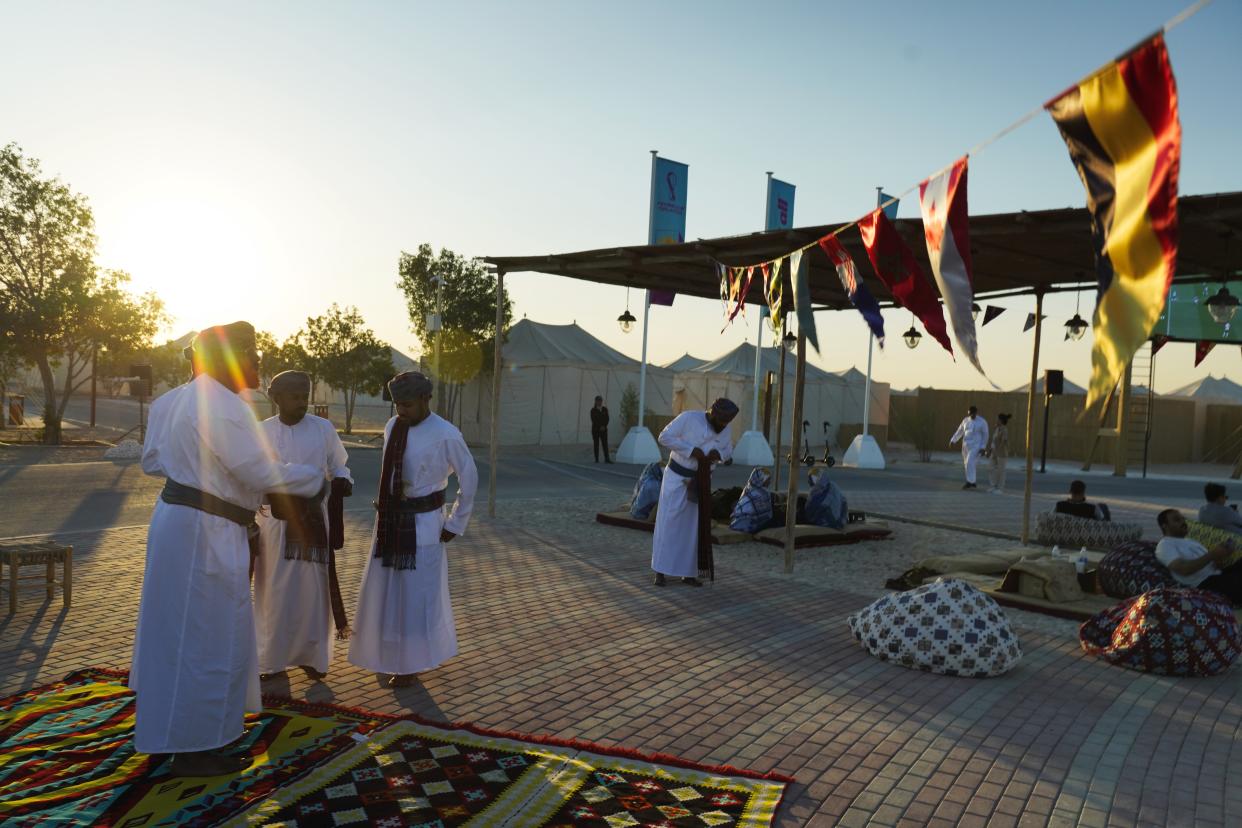 Omani performers prepare for a show for guests at a tent camp site in Al Khor, Qatar, Wednesday, Nov. 23, 2022. For scores of foreign soccer fans, the road to the World Cup in Doha starts every morning at a barren campsite in the middle of the desert. Visitors who found hotels in central Doha booked up or far beyond their budget have settled for the faraway, dust-blown tent village in Al Khor, where there are no locks on tents nor beers on draft. (AP Photo/Jon Gambrell)