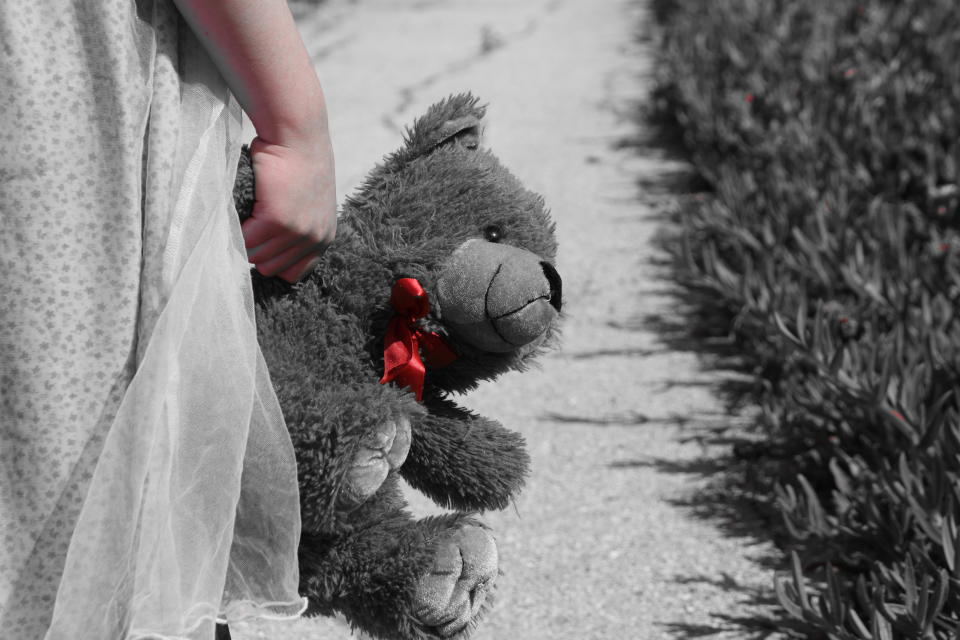 A little girl holding a teddy bear