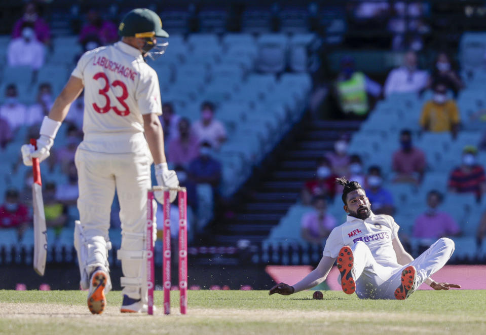 India's Mohammed Siraj falls as he fields the ball hit by Australia's Marnus Labuschagne, left, during play on day three of the third cricket test between India and Australia at the Sydney Cricket Ground, Sydney, Australia, Saturday, Jan. 9, 2021. (AP Photo/Rick Rycroft)