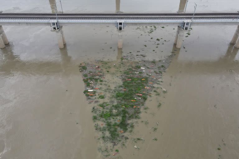 En esta foto aérea, el aumento del nivel del agua del río Ganges lava la escasa capa de suelo y deja al descubierto las tumbas