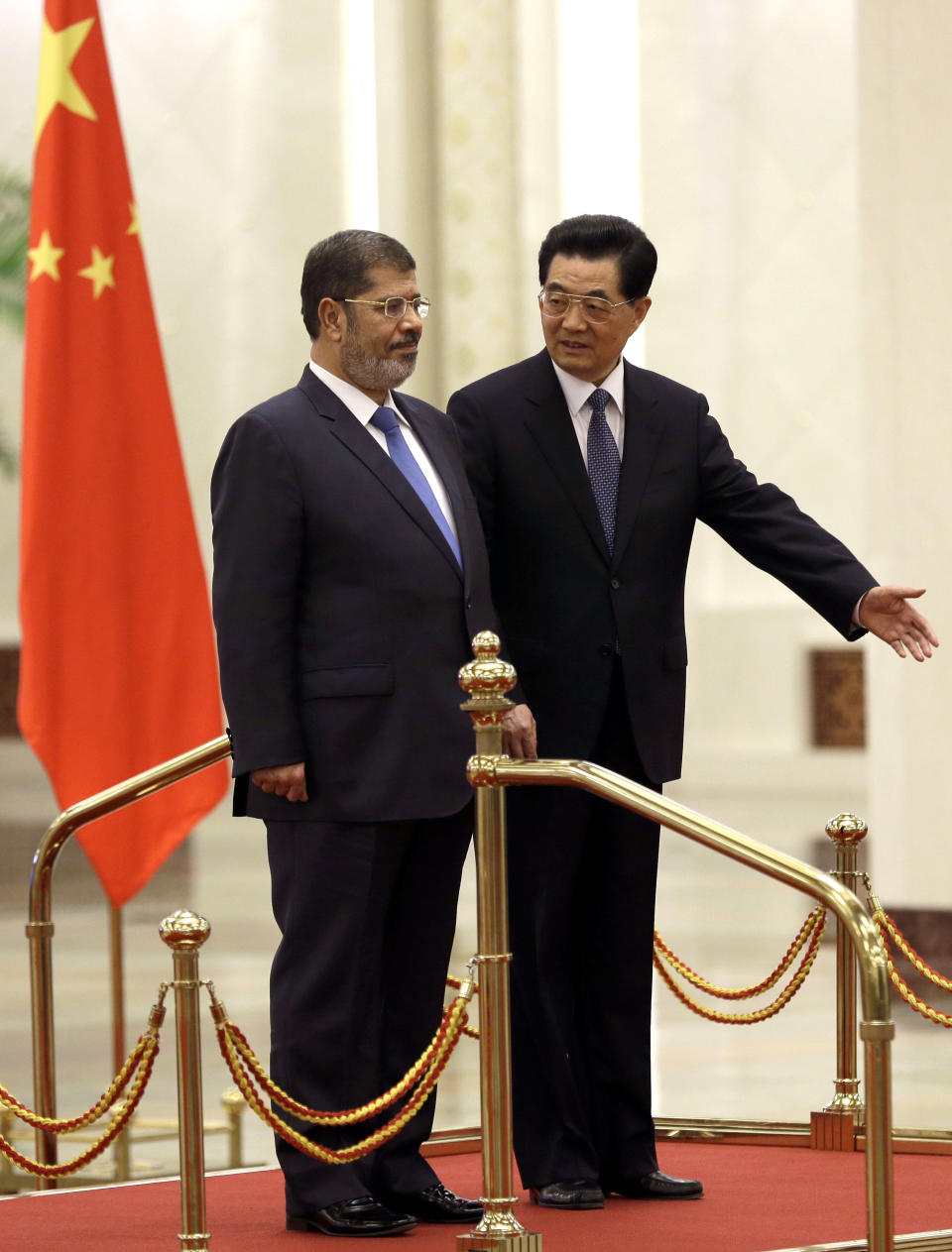 Egyptian President Mohammed Morsi, left, is shown the way by Chinese President Hu Jintao during a welcome ceremony held at the Great Hall of the People in Beijing Tuesday, Aug. 28, 2012. China is hosting Egypt's newly elected president despite its uneasiness with the Arab Spring revolution that helped bring him to power, while the new leader seeks to shore up his country's flagging economy. (AP Photo/Ng Han Guan)