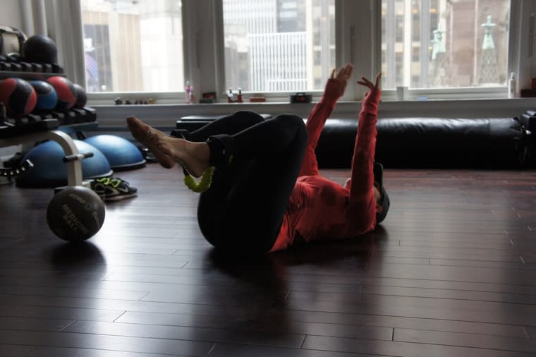 Ary demonstrates the first floor exercise, showing me how to bring my toes all the way up, keeping…