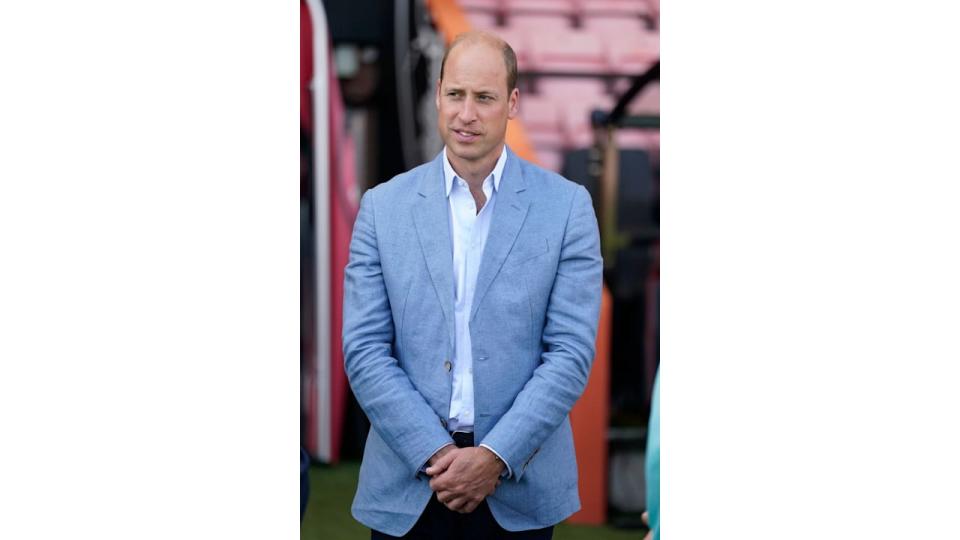 Prince William in a light blue jacket and shirt inside a football stadium