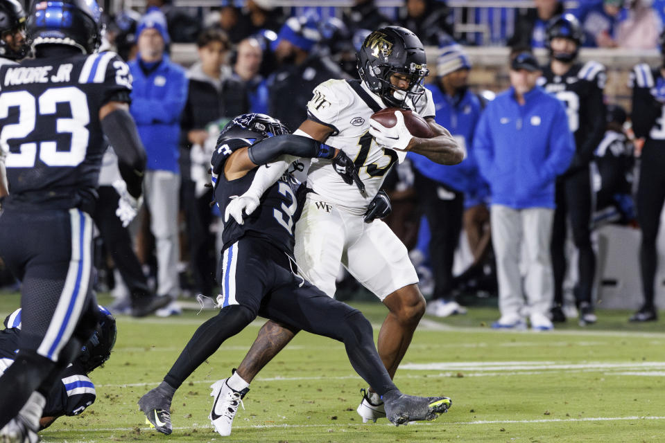 Wake Forest's Ke'Shawn Williams (13) is tackled by Duke's Brandon Johnson (3) during the first half of an NCAA college football game in Durham, N.C., Thursday, Nov. 2, 2023. (AP Photo/Ben McKeown)