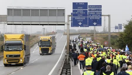 Harbor workers, storekeepers and residents march on the motorway to participate in a human chain protest demonstration against the migrant situation in Calais, France, September 5, 2016. REUTERS/Charles Platiau