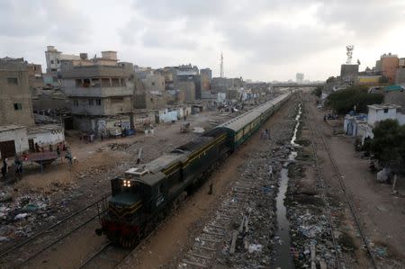 A passenger train moves along a neighbourhood in Karachi, Pakistan September 18, 2018. REUTERS/Akhtar Soomro/Files