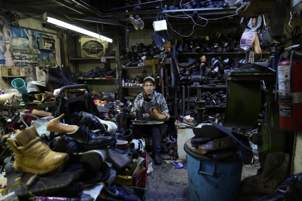 José Francisco Rodríguez , a cobbler for 46 years, poses for a portrait at his workshop in Caracas, Venezuela, Friday, Feb. 24, 2023. Rodríguez said he has “faith in Venezuela” and would never migrate, a decision he acknowledged he can make because he owns a well-established business. (AP Photo/Ariana Cubillos)