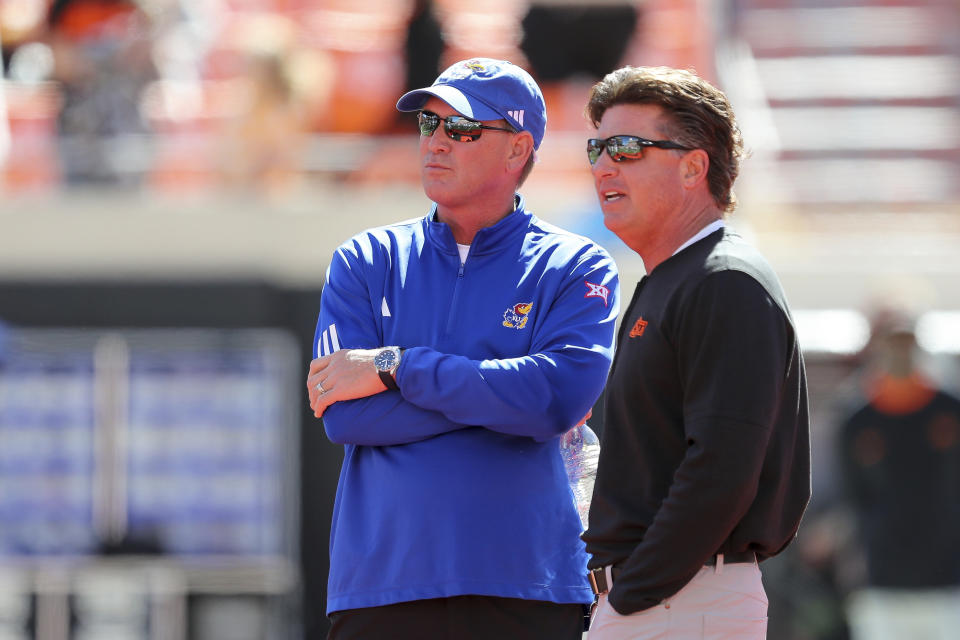 Kansas's Lance Leipold and Oklahoma State's Mike Gundy meet with each other before an NCAA college football game in Stillwater, Okla., Saturday, Oct. 14, 2023. (AP Photo/Mitch Alcala)