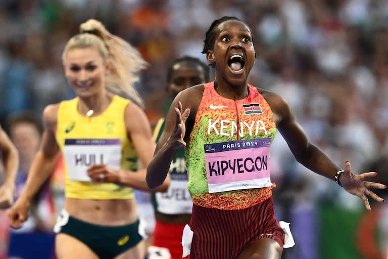 Faith Kipyegon, medallista de oro de Kenia, empieza a celebrar mientras cruza la línea de meta en la final femenina de 1.500 m en los Juegos Olímpicos de París 2024 