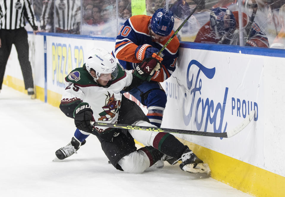 Arizona Coyotes' Barrett Hayton (29) is checked by Edmonton Oilers' Derek Ryan (10) during the first period of an NHL hockey game in Edmonton, Alberta, Wednesday, March 22, 2023. (Jason Franson/The Canadian Press via AP)