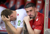 Cologne's Dominique Heintz, left, and substitute goalkeeper Philipp Pentke sit disappointed after the Bundesliga soccer match between Heidenheim and Köln at the Voith-Arena in Heidenheim, Germany, Saturday, May 18, 2024. (Harry Langer/dpa via AP)