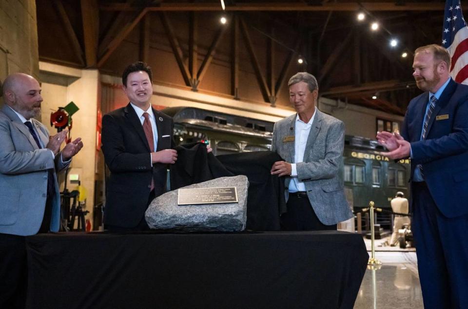 The California State Railroad Museum and Foundation dedicate the Chinese Railroad Workers’ Experience exhibit to civic leader and philanthropist Dr. Herbert Yee with a rock-mounted plaque Wednesday, June 21, 2023, during a ceremony at the Sacramento museum. Museum director Ty Smith, far left, and foundation president Tim Schroepfer stand on either side of the late Dr. Yee’s grandson Dr. David Yee, left, and son Dr. Wesley Yee.