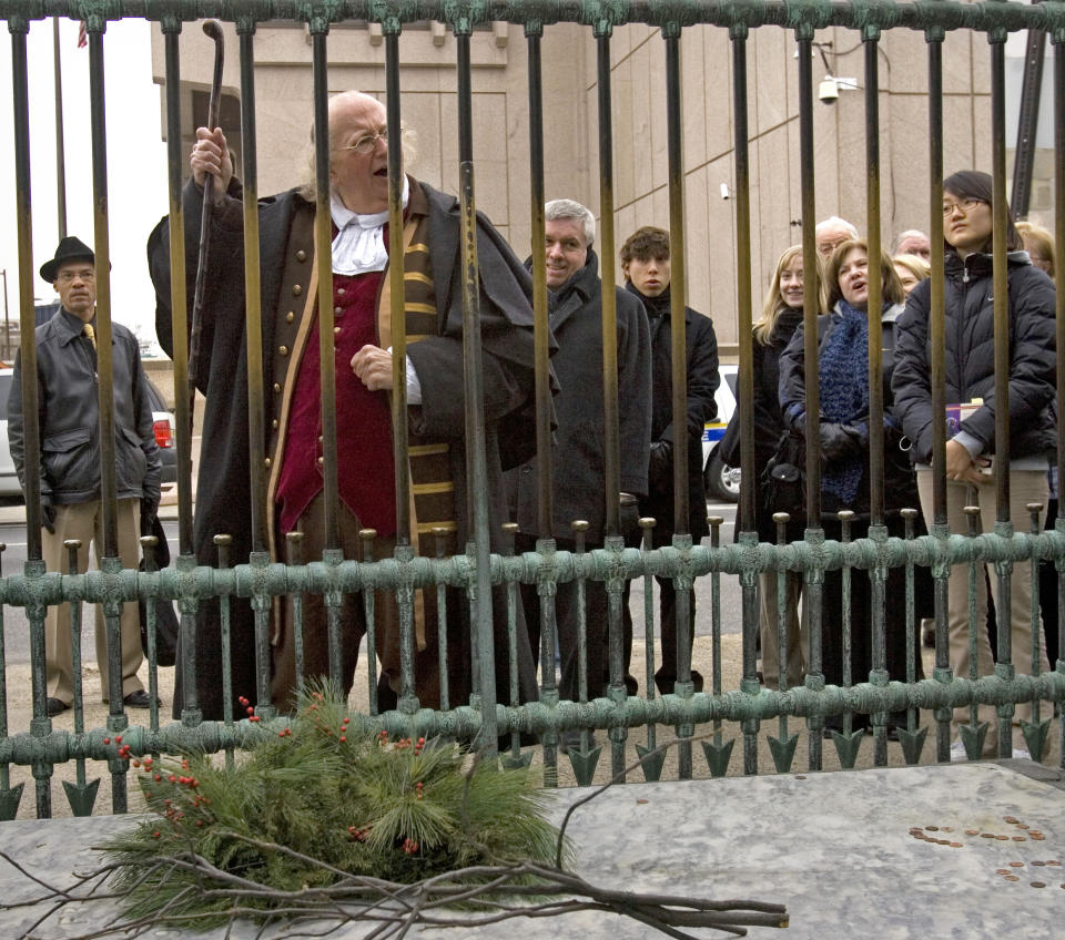 FILE – In this Jan. 17, 2008, file photo, re-enactor Ralph Archbold, portraying Benjamin Franklin, cheers during a ceremony to mark the 302nd anniversary of Franklin's birth on Jan. 17, 1706, at Franklin's grave at Christ Church Burial Ground in Philadelphia. Archbold, who portrayed Benjamin Franklin in Philadelphia for more than 40 years, died Saturday, March 25, 2017, at age 75, according to the Alleva Funeral Home in Paoli, Pa. (AP Photo/Matt Rourke, File)