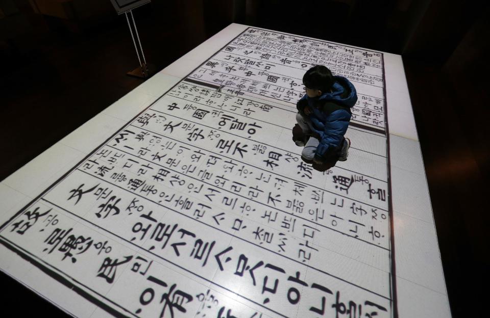 In this Wednesday, Dec. 28 photo, a boy sits on a screen showing Korean traditional characters at the National Hangeul Museum in Seoul, South Korea. Impeached President Park Geun-hye's surname is "Park," right? Nope. In Korean it's closer to "Bahk." Park's allegedly corrupt confidante, Choi Soon-sil, pronounces her name more like "Chwey" than the way it's rendered in English. There is a gulf, often a wide one, between the way Koreans write their names in English and the way they actually sound. (AP Photo/Ahn Young-joon)