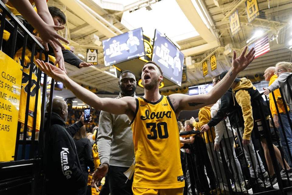 Iowa guard Connor McCaffery celebrates with fans after an NCAA college basketball game against Michigan State, Saturday, Feb. 25, 2023, in Iowa City, Iowa. Iowa won 112-106 in overtime. (AP Photo/Charlie Neibergall)
