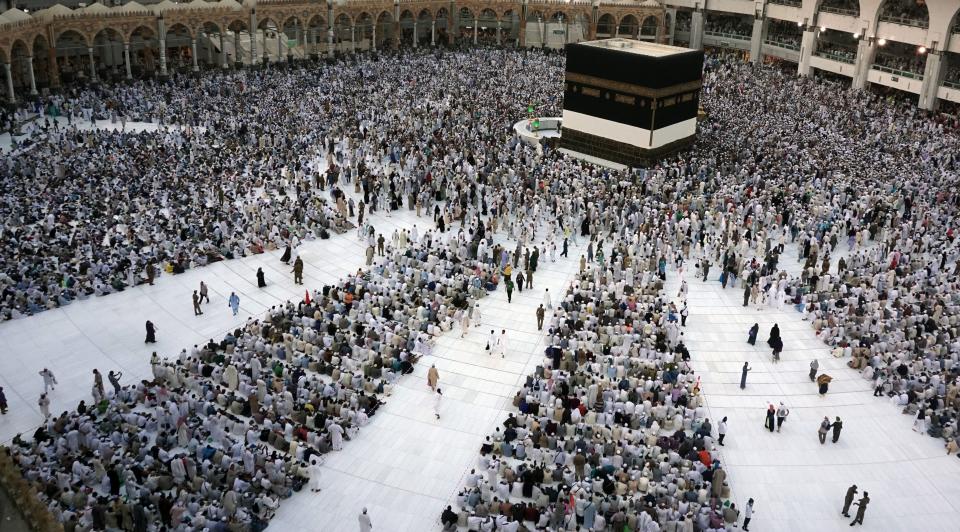 Muslim pilgrims sit and circumambulate around the Kaaba, the cubic building at the Grand Mosque.