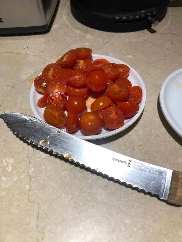 cherry tomatoes that have been sliced in half with a serrated knife