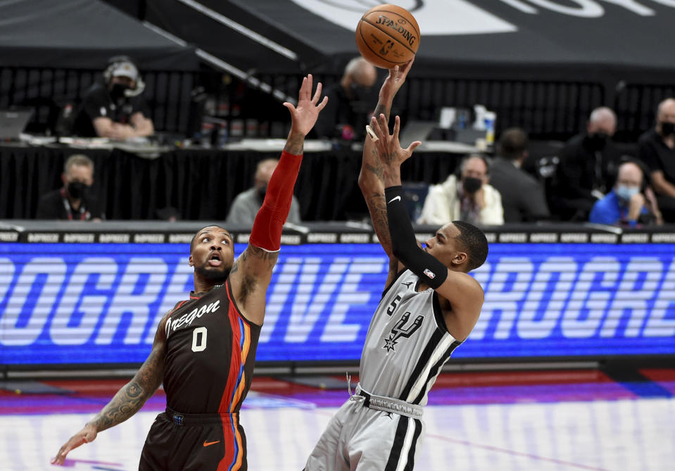 San Antonio Spurs guard Dejounte Murray, right, shoots over Portland Trail Blazers guard Damian Lillard during the first half of an NBA basketball game in Portland, Ore., Saturday, May 8, 2021. (AP Photo/Steve Dykes)