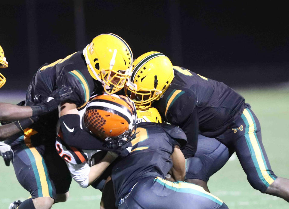 Taft's defense wraps up Versailles running back  Jack Osborne during their playoff game, Saturday, Nov. 13, 2021.