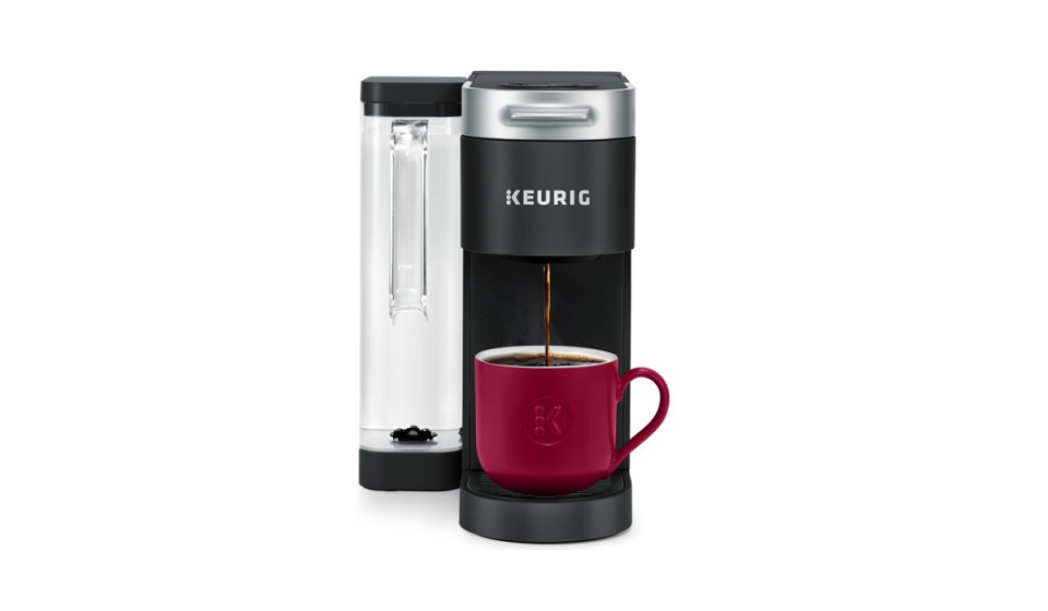 Keurig single-cup coffee brewer with side compartment for water and a red mug being filled with coffee.