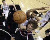 Portland Trail Blazers' Robin Lopez, front, shoots under San Antonio Spurs' Tim Duncan, back center, during the first half of Game 1 of a Western Conference semifinal NBA basketball playoff series, Tuesday, May 6, 2014, in San Antonio. (AP Photo/Eric Gay)