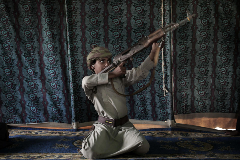 FILE - In this July 27, 2018, file photo, Kahlan, a 12-year-old former child soldier with Yemen's Houthi rebels, demonstrates how to use a weapon at a camp for displaced persons where he took shelter with his family in Marib, Yemen. President Joe Biden's announcement that the U.S. will end its support of a Saudi-led coalition's years-long war against Yemen's Houthi rebels likely will increase pressure on the kingdom to end its campaign there, though reaching an enduring peace for the Arab world's poorest country still remains in question. (AP Photo/Nariman El-Mofty, File)