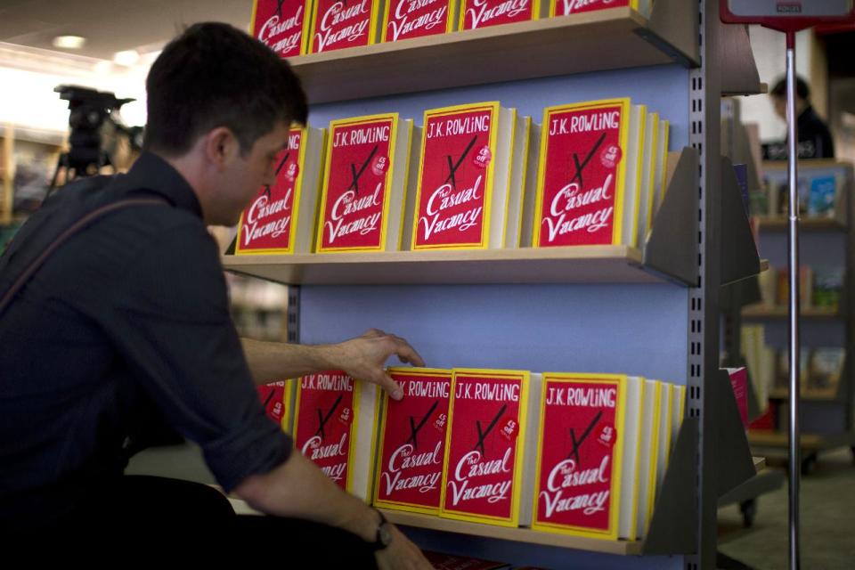 An employee adjusts copies of "The Casual Vacancy" by author J.K. Rowling at a book store in London, Thursday, Sept. 27, 2012. British bookshops are opening their doors early as Harry Potter author J.K. Rowling launches her long anticipated first book for adults. Publishers have tried to keep details of the book under wraps ahead of its launch Thursday, but "The Casual Vacancy" has gotten early buzz about references to sex and drugs that might be a tad mature for the youngest "Potter" fans. (AP Photo/Matt Dunham)